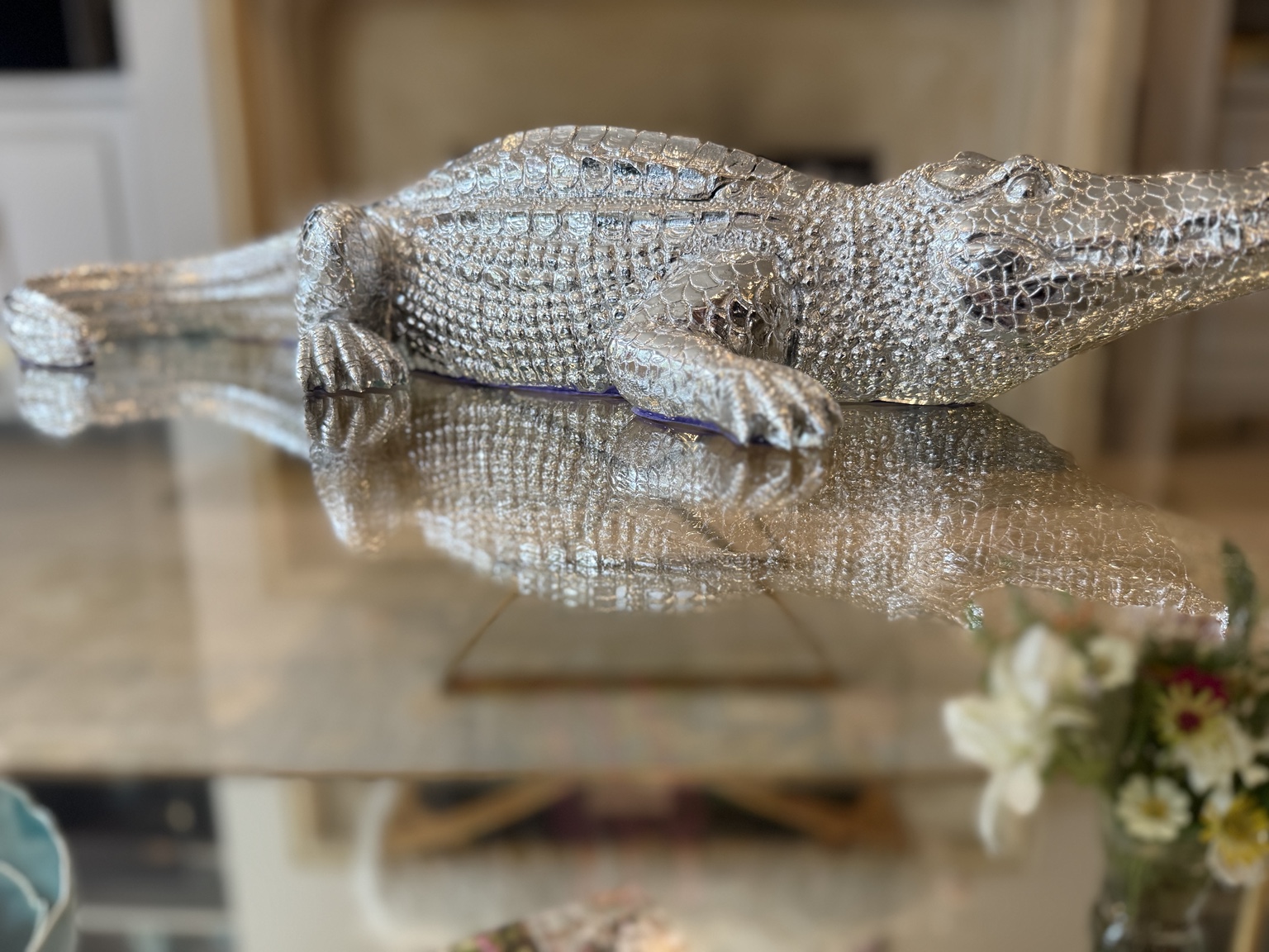 A full view of the sculptural silver alligator candle